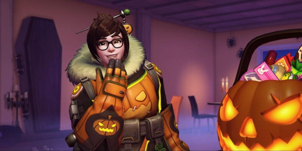 Mei in her Halloween-themed pumpkin skin from Overwatch 2, smiling next to a glowing jack-o'-lantern candy bucket