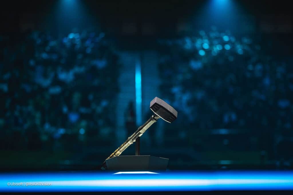 Image of Six Invitational trophy placed on a stand while lights illuminate it from above